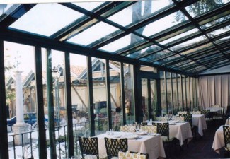Cerramiento de cristal con puertas correderas y estructura de techo metálica para un restaurante en Valencia.