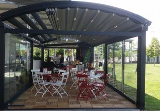 Cerramiento de cristal con puertas correderas y estructura de techo metálica para un restaurante en Valencia.